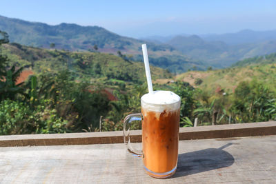 Close-up of drink on table against sky