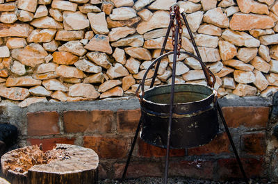 Close-up of fire pit against stone wall at back yard