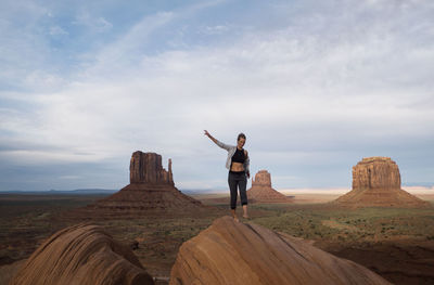 Rear view of man standing on landscape against sky