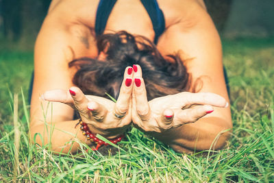 Midsection of woman lying down on field