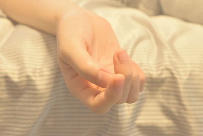 Close-up of baby hand on bed