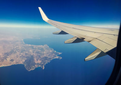 Aerial view of airplane wing against clear blue sky