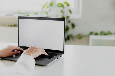 Cropped hands using laptop on table