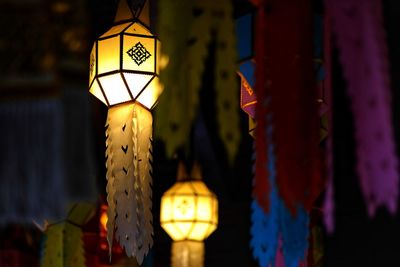 Low angle view of illuminated lanterns hanging at night