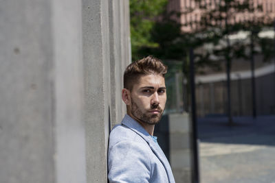 Portrait of man standing against wall