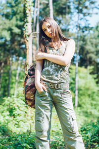 Full length of young woman standing in forest