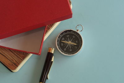 Directly above shot of navigational compass on blue background