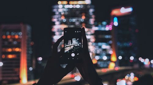 Close-up of hand using mobile phone at night