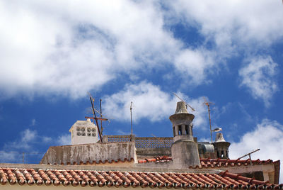 A traditional red tile rooftop with chimneys in a small portuguese town