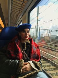 Thoughtful woman sitting in train at winter