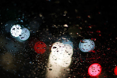 Colorful lights seen through wet glass during rainy season