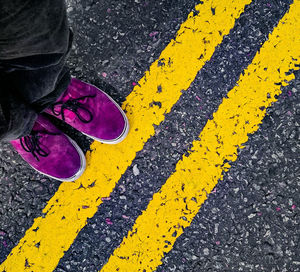 Low section of man wearing shoes standing on street