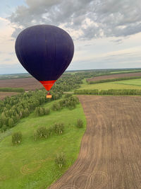 Hot air balloons on field against sky