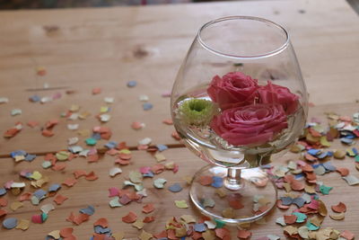 High angle view of rose in glass on table