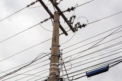 Low angle view of electricity pylon against sky