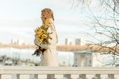 A woman with a bouquet of acacia flowers. the concept of the spring - march 8, easter, women's day