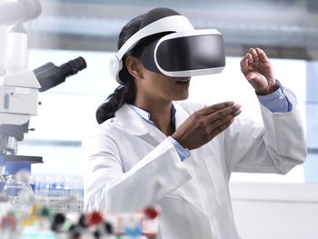Female scientist using virtual reality to understand a research experiment in the laboratory