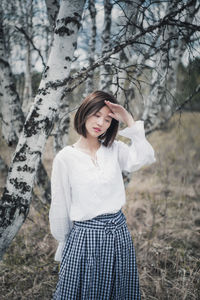 Young woman standing on field in forest