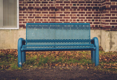 Empty chairs against brick wall