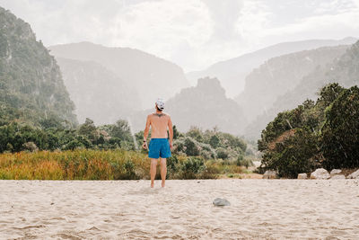 Rear view of man looking at mountain range