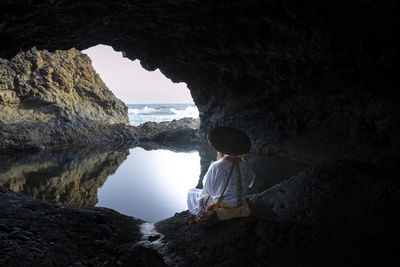 Rear view of man standing in cave