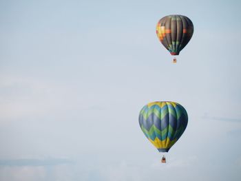 Low angle view of hot air balloons flying against sky