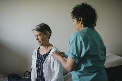 Female doctor examining senior patient in clinic