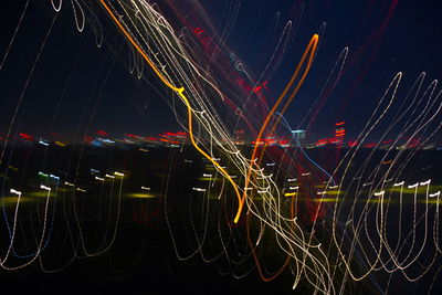 Low angle view of light trails against sky at night