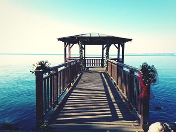 Pier over sea against clear sky