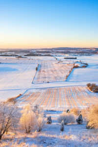 Scenic view of snow covered land during sunset