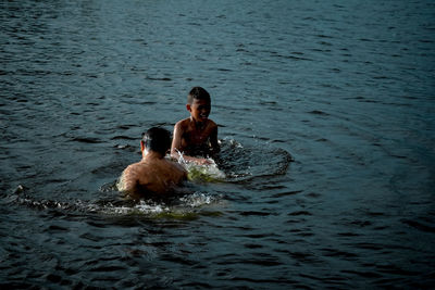 Full length of shirtless man swimming in sea