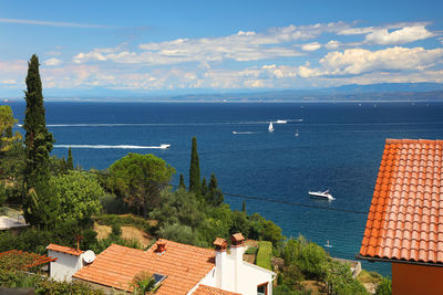 High angle view of houses by sea against sky