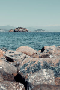 Scenic view of rocks in sea against clear sky