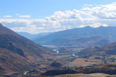 Scenic view of valley and mountains against sky