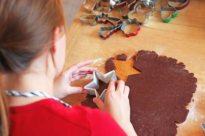 High angle view of woman holding food on table