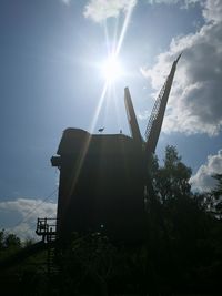 Low angle view of traditional windmill against sky on sunny day