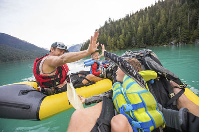 Paddlers high-five during a father son paddling trip