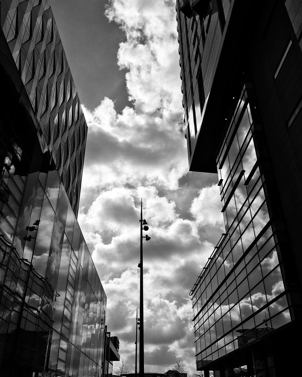 building exterior, architecture, built structure, low angle view, sky, city, building, cloud - sky, modern, office building, tall - high, cloud, cloudy, residential building, window, residential structure, day, outdoors, tower, street light