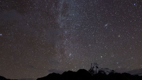 Night sky star field over mountain peaks