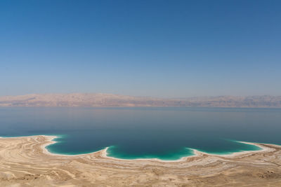 Scenic view of lake against clear blue sky