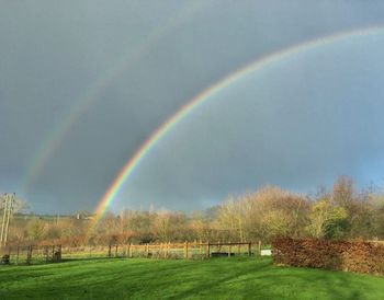 Rainbow over landscape against sky