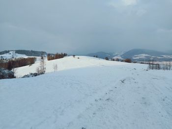 Scenic view of snow covered land against sky