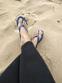 Low section of woman legs on sand