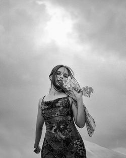 Low angle view of woman standing against sky