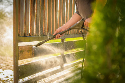 Cropped hand of man cleaning gate