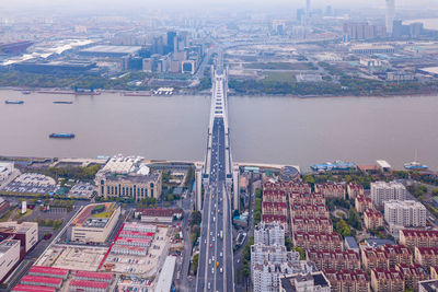 High angle view of modern buildings by river in city