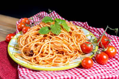 Close-up of noodles with cherry tomatoes served on table