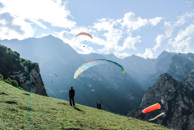 People on mountain range against sky