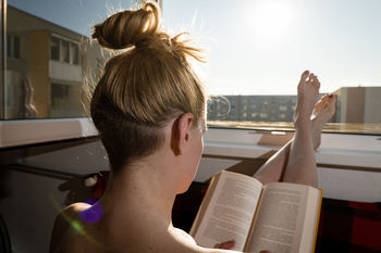 Rear view of woman sitting by window