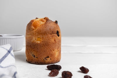 Festive christmas dessert panettone with raisins on white wooden table